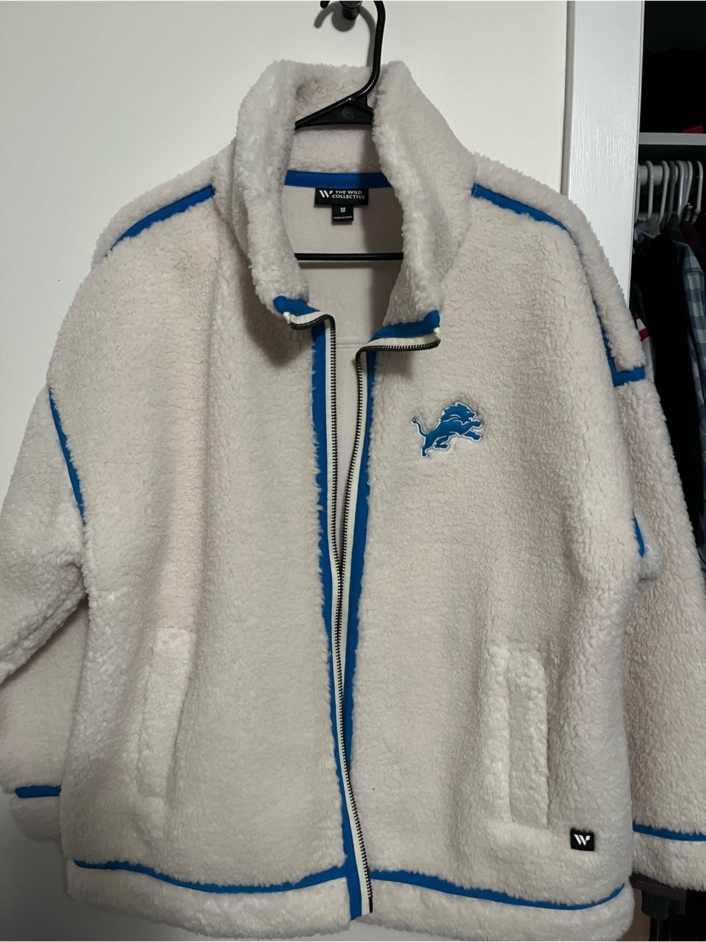 The Wild Collective White Sherpa Jacket with Blue Trim & Lions Patch